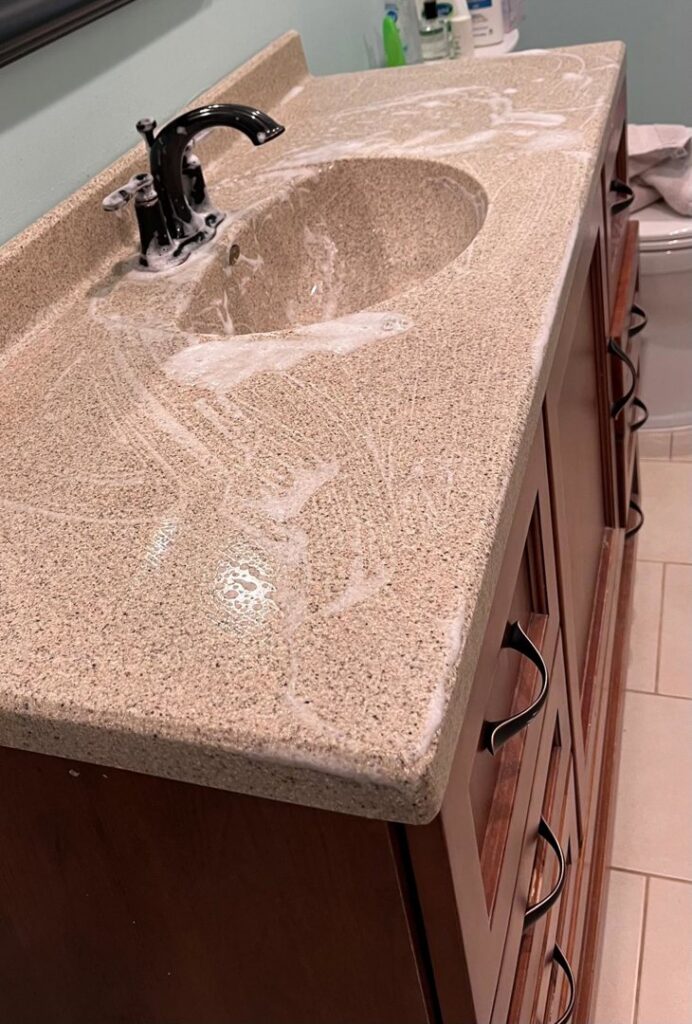 A bathroom vanity countertop covered in cleaning foam, showing a house cleaning job in progress by Nichelle's touch housekeeping LLC in Detroit, MI.