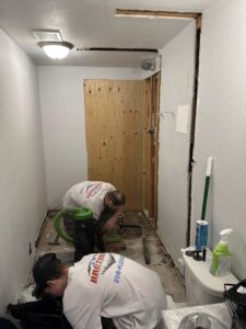 Workers from Brothers Restoration performing water damage cleanup and restoration in a bathroom in Post Falls, ID.