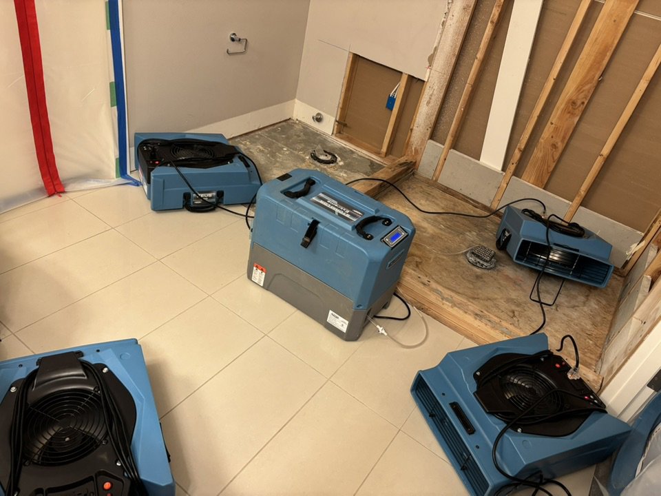 A bathroom undergoing water damage drying and demolition with air movers and exposed studs by Utah Flood Guys in Sandy, UT.