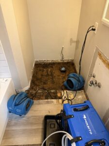 A bathroom undergoing water damage drying with air movers and a dehumidifier by Harbaugh Restoration in Vancouver, WA.