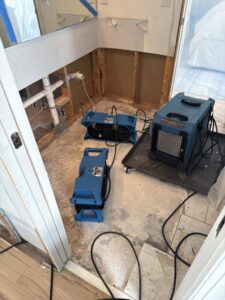 A bathroom undergoing water damage drying with air movers and dehumidifiers by Triangle Restoration in Raleigh, NC.