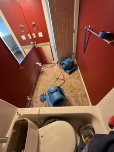 A bathroom undergoing water damage drying with air movers and exposed subfloor by Idaho Disaster Pros in Idaho Falls, ID.