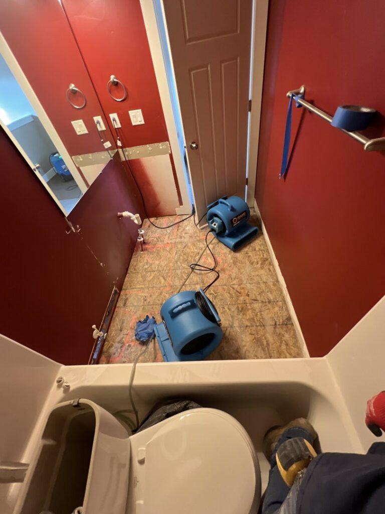 A bathroom undergoing water damage drying with air movers and exposed subfloor by Idaho Disaster Pros in Idaho Falls, ID.