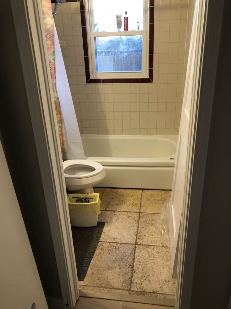 A bathroom undergoing water damage repair with removed floor tiles by Plumb Tech Inc in Midwest City, OK.
