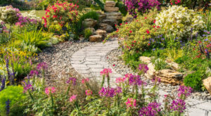 A beautifully landscaped garden with a winding stone path and colorful flowers, showcasing yard services by LTN Yard Services LLC in Kaneohe, HI.