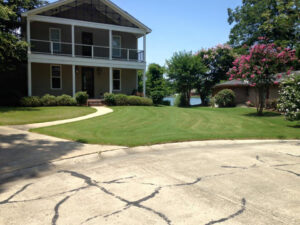 A beautifully maintained residential lawn with clear mow lines, overlooking a lake, cared for by Pro Green, LLC in Greenville, MS.