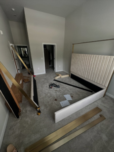 Unassembled bed frame parts, including a headboard and tools, ready for assembly by Mr Capitol Services llc in Laurel, MD.