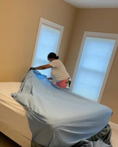 A house cleaner making a bed in a bedroom for TAG Team Cleaning of West Hartford, CT
