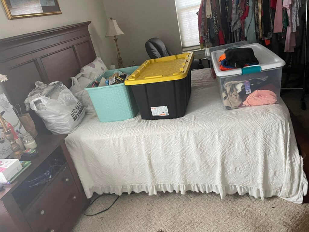 A bedroom with storage bins on the bed, illustrating a decluttering and organizing service by Skedaddle Cleaning Services in Eufaula, AL.