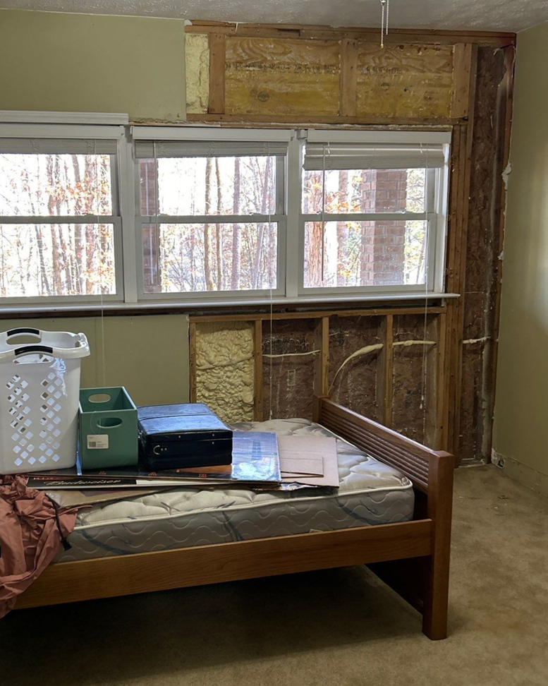 A bedroom with drywall removed, exposing studs and insulation, during water damage restoration by Level Creek Property Restoration in Buford, GA.