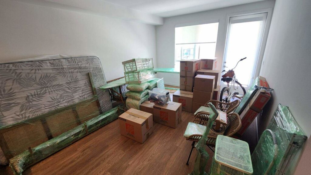 A bedroom with furniture and boxes packed and shrink-wrapped, ready for moving by Packman Moving in San Diego, CA