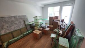 A bedroom with furniture and boxes packed and shrink-wrapped, ready for moving by Packman Moving in San Diego, CA