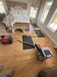 Water damage drying equipment, including air movers and dehumidifiers, set up in a bedroom by Paul Davis of Norman & SW OKC in Norman, OK.