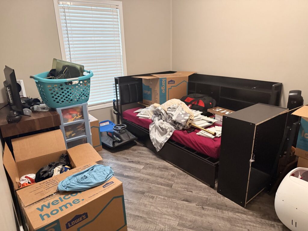 A bedroom filled with moving boxes and disassembled furniture, indicating a move in progress by Houston Affordable Movers in Houston, TX.