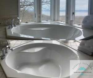 Before and after comparison of a bathtub, showing a dirty tub transformed into a sparkling clean one by Everest Cleaning LLC in East Peoria, IL