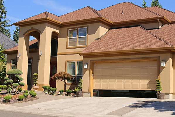 A residential home with a beige garage door partially open, serviced by Sawtooth Garage Doors in Boise, ID.