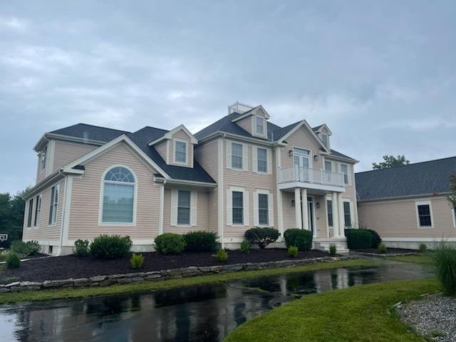 A large residential home featuring new beige horizontal siding installed by Atlantic Roofing and Siding in East Hartford, CT.