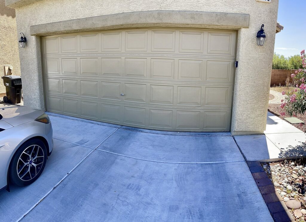 A newly installed beige panel garage door on a residential home by NV Pro Garage Doors in Las Vegas, NV.