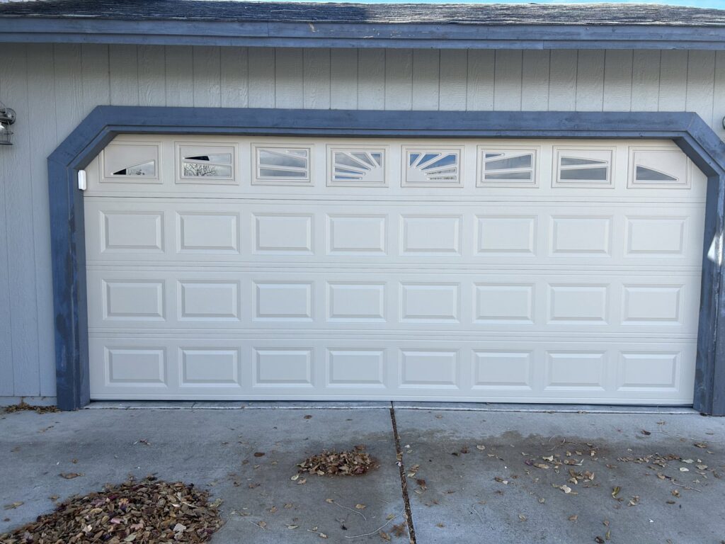 A newly installed beige paneled garage door with decorative windows by Summit-Overhead-Door in Sparks, NV.