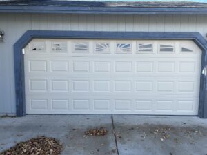 A newly installed beige paneled garage door with decorative windows by Summit-Overhead-Door in Sparks, NV.