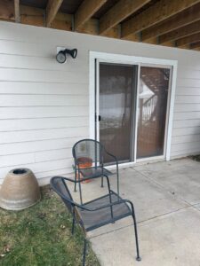 Newly installed light beige siding visible next to a sliding patio door, completed by Bishop Exteriors in Omaha, NE.