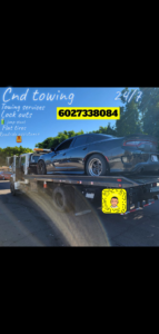 A black car being transported on a flatbed tow truck by CnD towing in Phoenix, AZ.