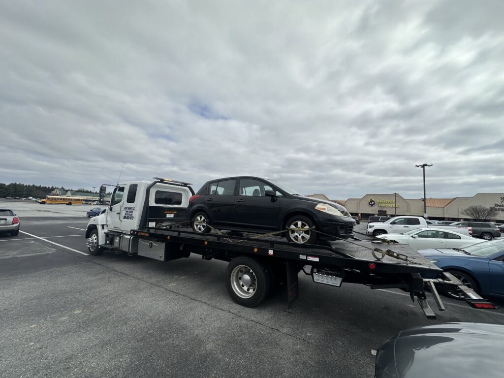 A black car loaded onto a flatbed tow truck from Nacho Transports llc in Middletown, DE.