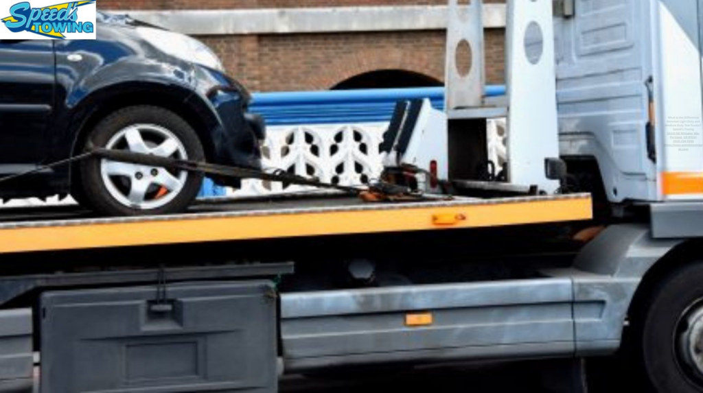 A black car being transported on a flatbed tow truck by Speed's Towing in Vancouver, WA.