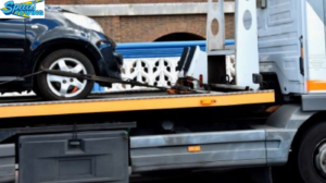 A black car being transported on a flatbed tow truck by Speed's Towing in Vancouver, WA.