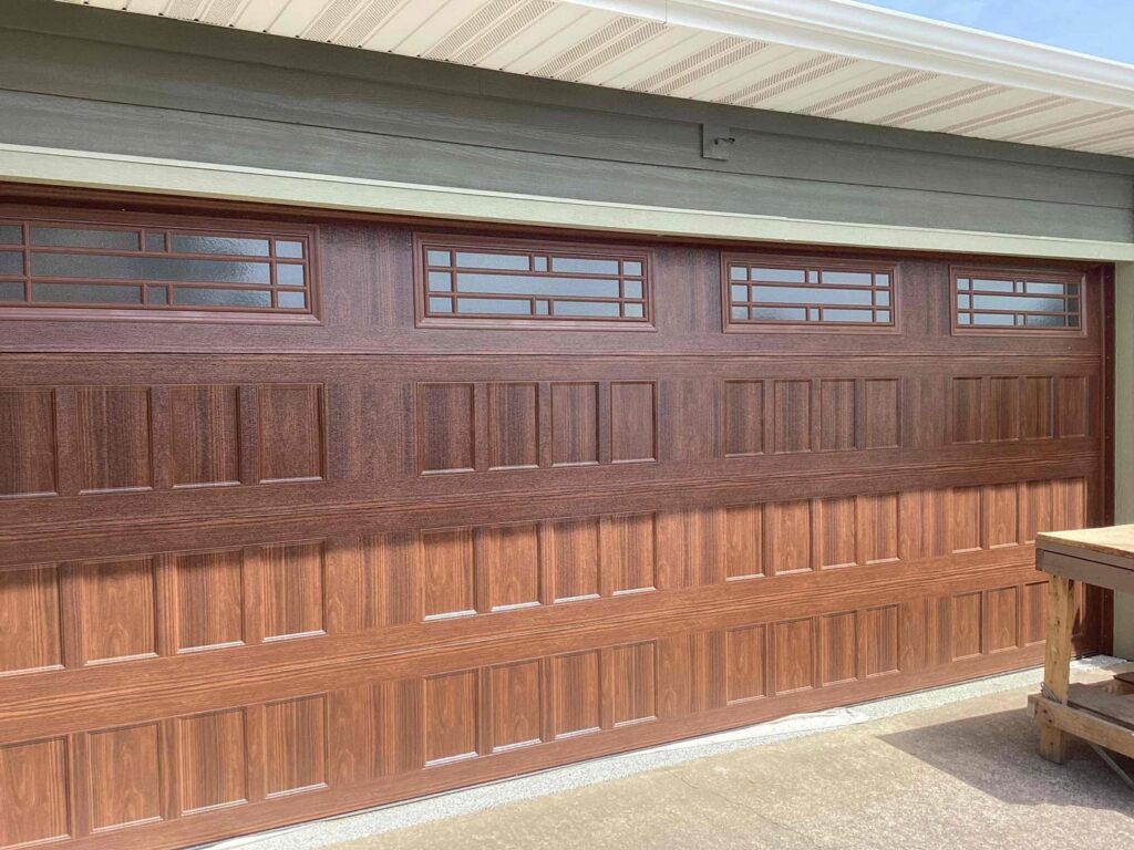 A black carriage house style garage door with windows installed by Fayetteville Garage Door Co. in Fayetteville, AR