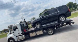 A black Chevy Tahoe SUV loaded onto a flatbed tow truck from Wilkerson's Towing & Automotive LLC in Bowling Green, KY.