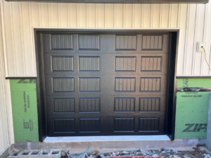 Exterior view of a newly installed black garage door by Complete Garage Solutions NWA in Centerton, AR.