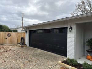 A newly installed black garage door on a brick home by LaFrancis Overhead Door LLC in Little Rock, AR