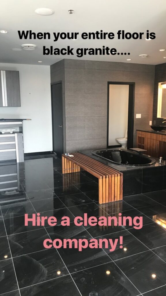 A luxurious bathroom featuring a black granite floor and bathtub, highlighting a space that benefits from professional cleaning by The Cleaning Fairy in Fort Lauderdale, FL.