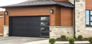A black modern garage door with horizontal windows installed on a contemporary home by K & B Door Co. in Las Vegas, NV