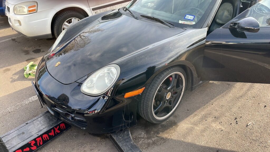 A black Porsche being carefully loaded onto a flatbed tow truck by Towing Colorado in Colorado Springs, CO.