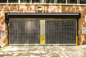 A black rolling grille garage door installed at a parking garage entrance by Wayne Dalton Sales & Service of Quad Cities in Davenport, IA.