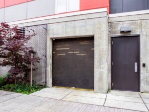 A black rolling steel garage door installed on a concrete building by Wayne Dalton Sales & Service of Quad Cities in Davenport, IA.