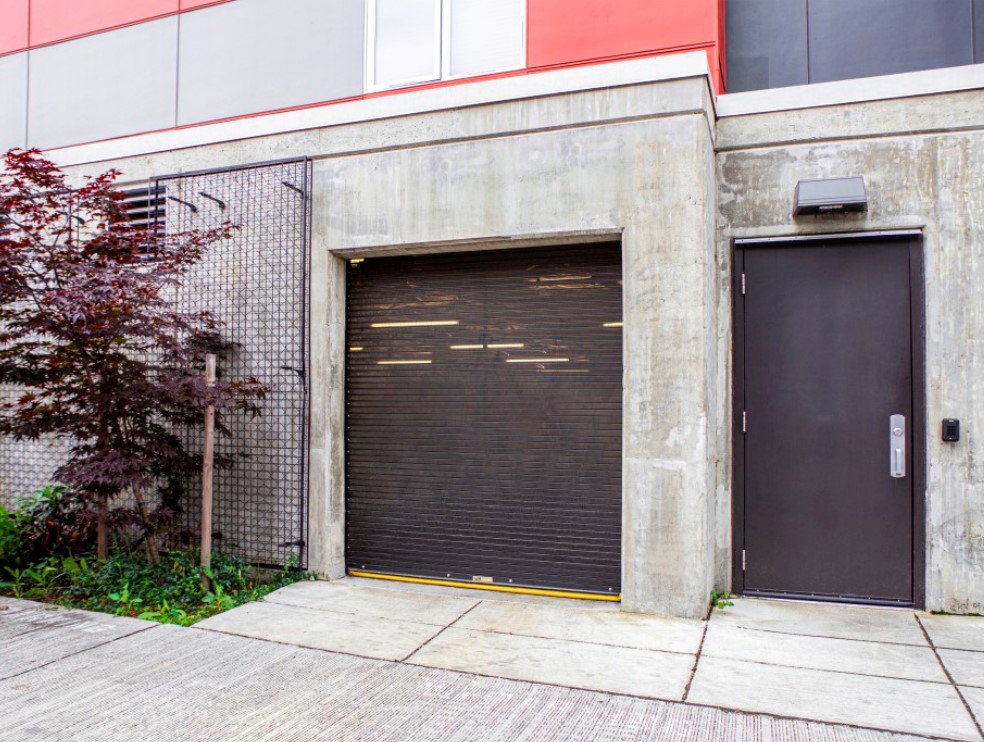 A black rolling steel garage door installed on a concrete building by Wayne Dalton Sales & Service of Quad Cities in Davenport, IA.