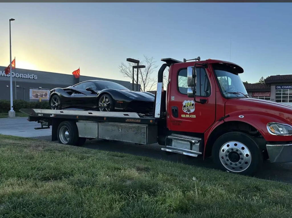 A black sports car being transported on a flatbed tow truck by 101 auto towing inc in San Jose, CA.