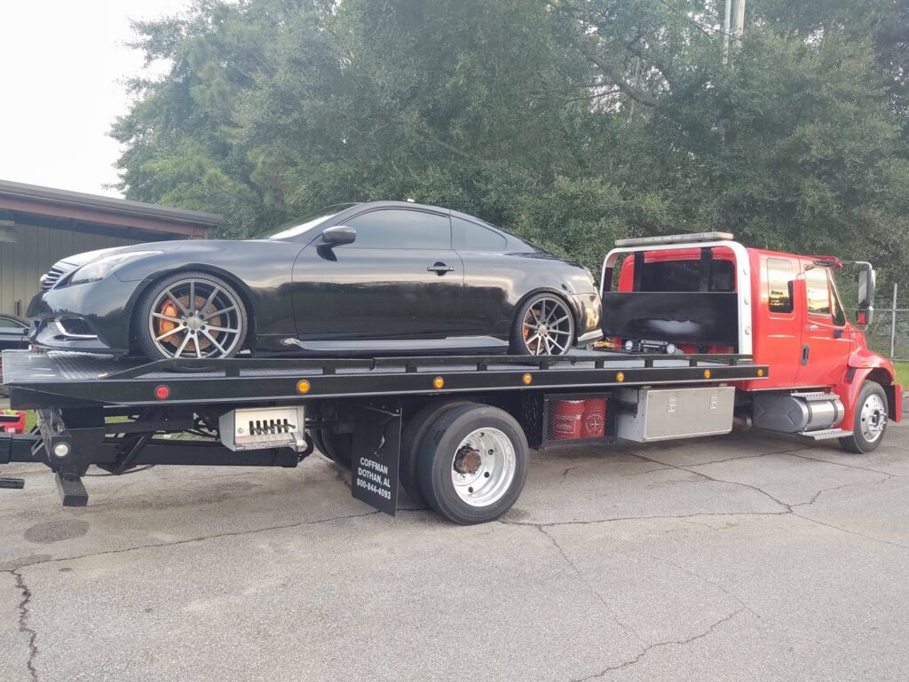 A black sports car loaded onto a flatbed tow truck from Full Circle Towing and Recovery in Dothan, AL.