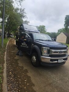 A black SUV loaded onto a flatbed tow truck from Jay Towing Services, ready for transport in Houston, TX.