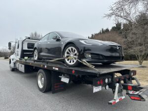 A black Tesla loaded onto a flatbed tow truck from Nacho Transports llc in Middletown, DE.
