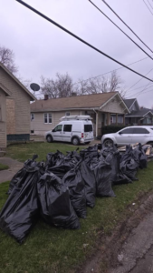 Numerous black trash bags piled on a lawn after a thorough cleanout by Klean Cut Cleaning in Flint, MI.