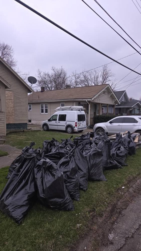 Numerous black trash bags piled on a lawn after a thorough cleanout by Klean Cut Cleaning in Flint, MI.