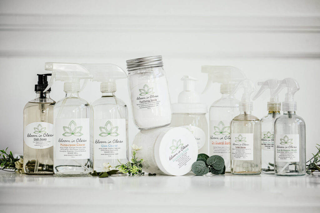 A collection of Bloom in Clean branded cleaning products, including spray bottles and jars, for house cleaning services in Bangor, ME.