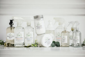 A collection of Bloom in Clean branded cleaning products, including spray bottles and jars, for house cleaning services in Bangor, ME.
