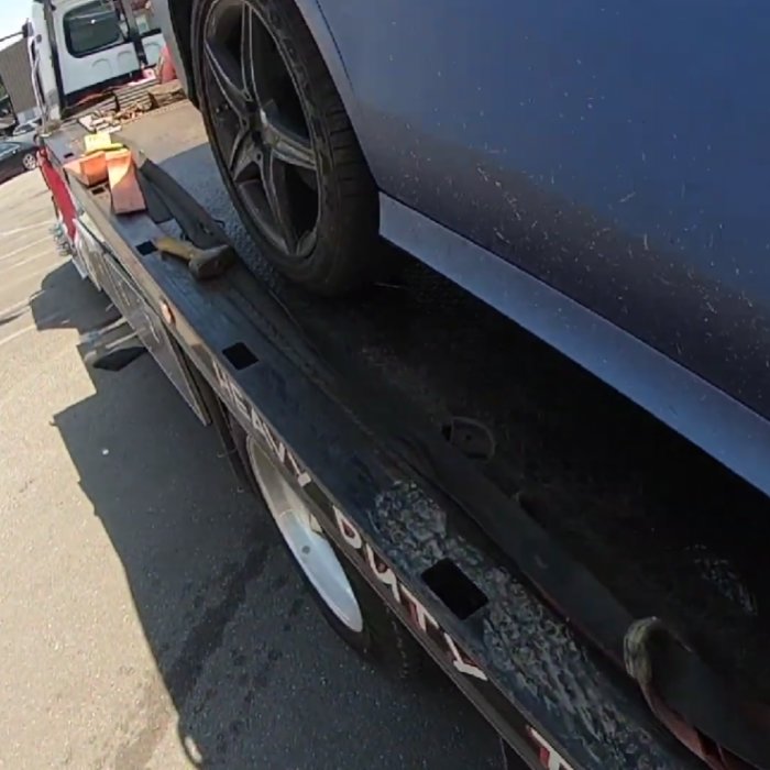 A blue car's wheel secured on a heavy-duty flatbed tow truck by Columbus Towing in Columbus, GA.
