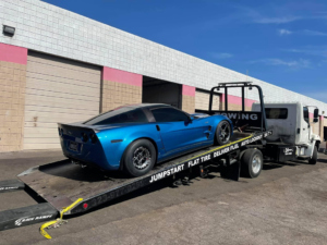 A blue Corvette sports car loaded onto a flatbed tow truck by Rojo's Towing in Phoenix, AZ.