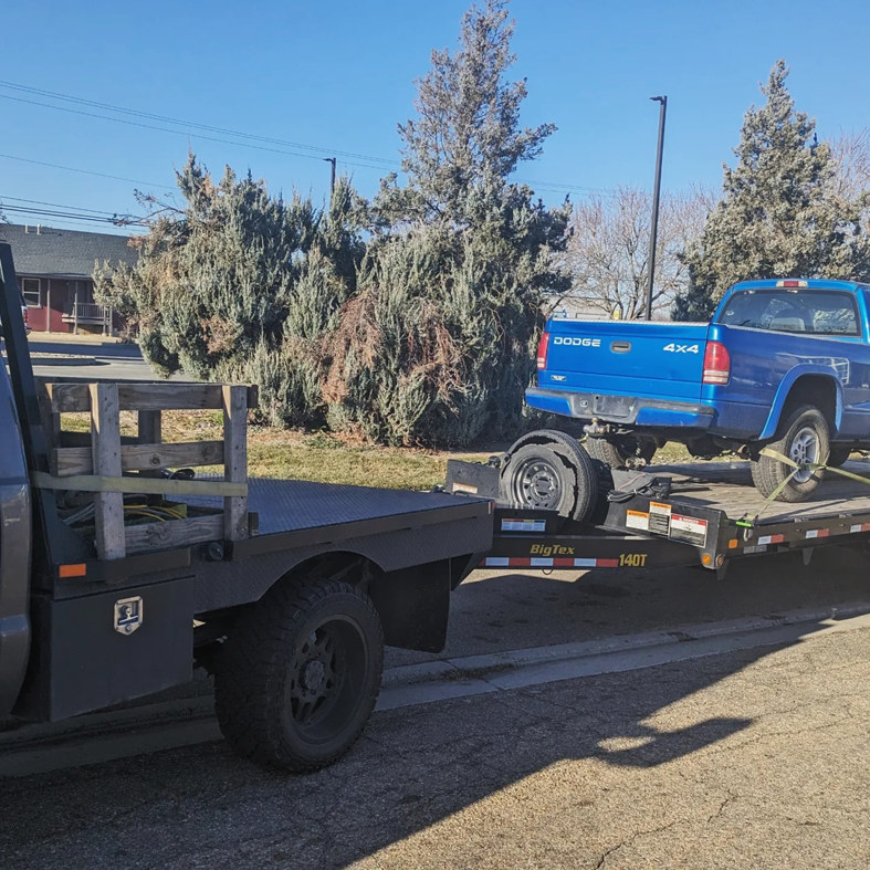 A blue Dodge pickup truck loaded onto a flatbed trailer by Mountain Goat Rescue & Recovery LLC + Towing in Nampa, ID.